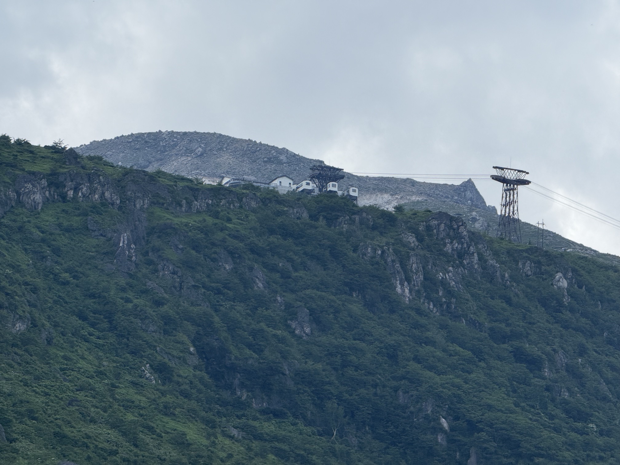 那須岳の山腹に見えるロープウェイ乗り場と岩肌の風景
